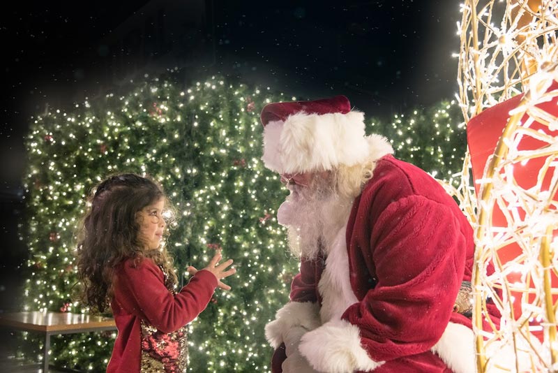 Santa Claus with child at Enchant Christmas - Dazzling holiday display, market and light maze in Washington, DC