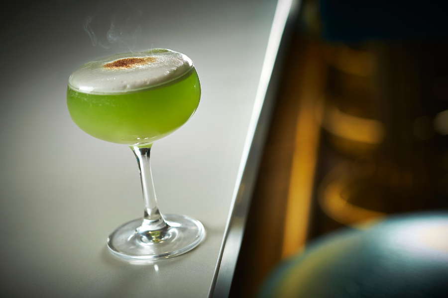 Green cocktail drink on a white bar