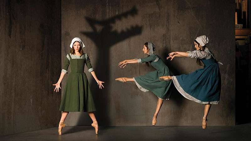 Three ballerinas on stage dressed in quaker outfits playing in The Crucible